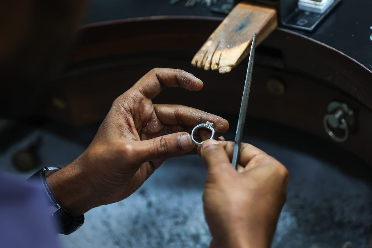 Gullsmed tar inn en ring i størrelse ved å fjerne et stykke metall og lodde sammen